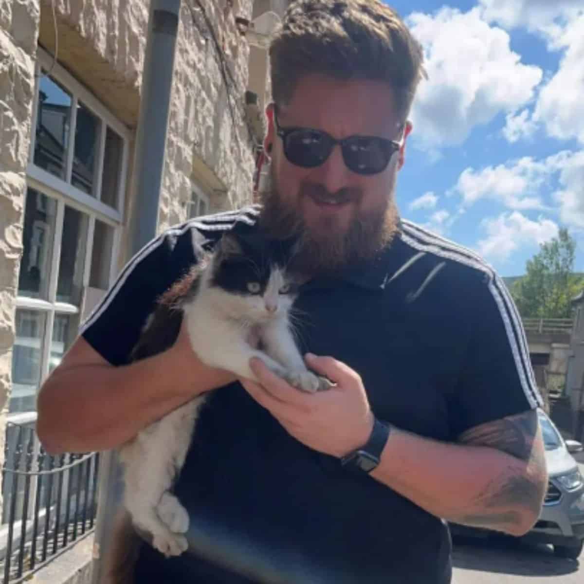 man carrying a kitten